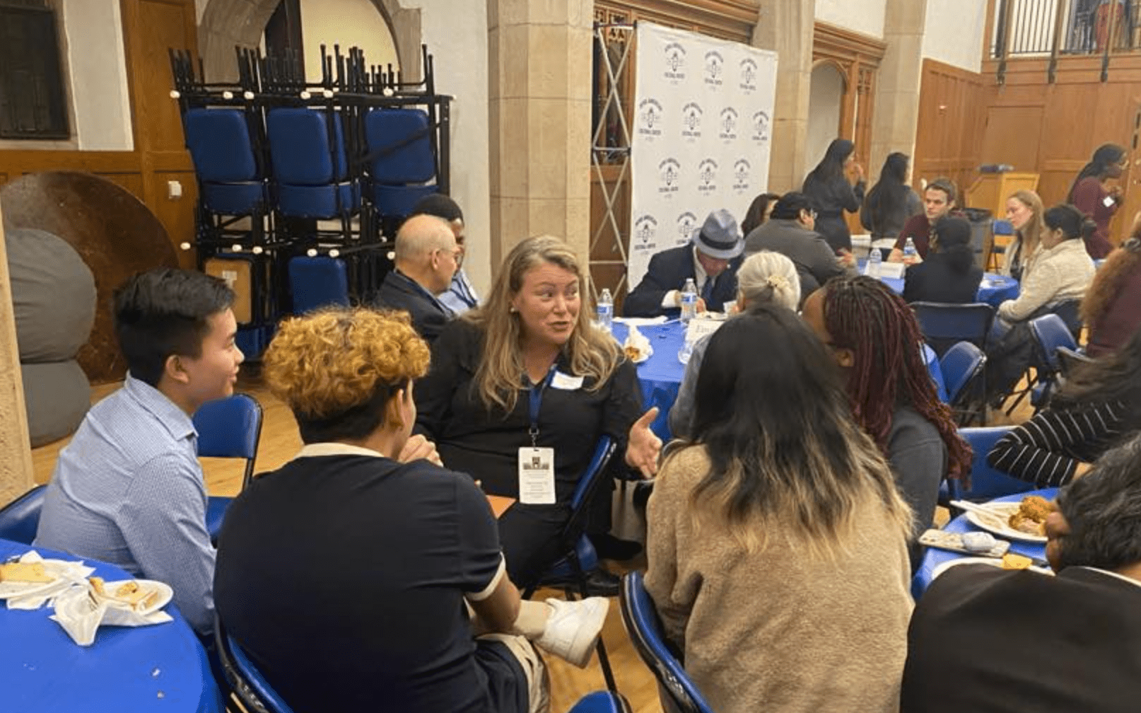 Students and alumni talking while seated at tables
